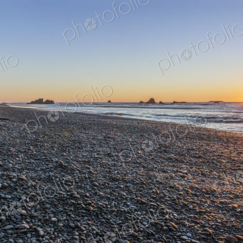 The view from Ruby Beach over the sea at sunset and sea stacks in the distance at… The view from Ruby Beach over the sea at sunset and sea stacks in the distance at…