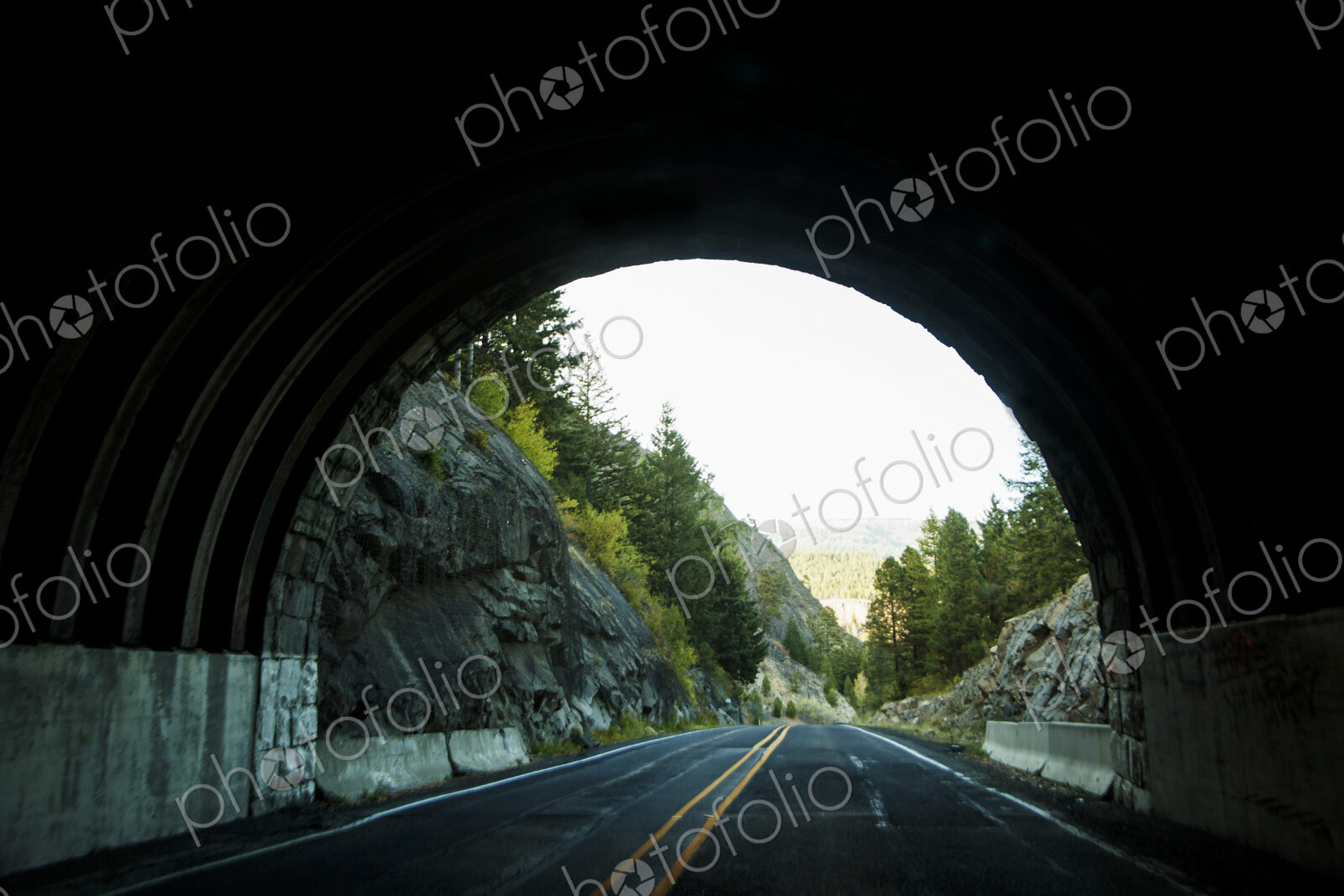 The view of the end of a road tunnel from the highway.