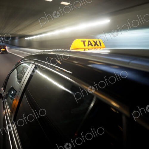 The yellow roof sign of a taxi driving through a tunnel. The yellow roof sign of a taxi driving through a tunnel.