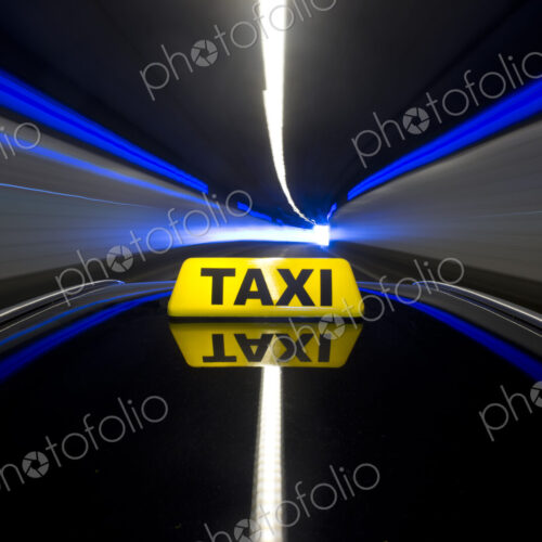 The yellow roof sign of a taxi driving through a tunnel. The yellow roof sign of a taxi driving through a tunnel.