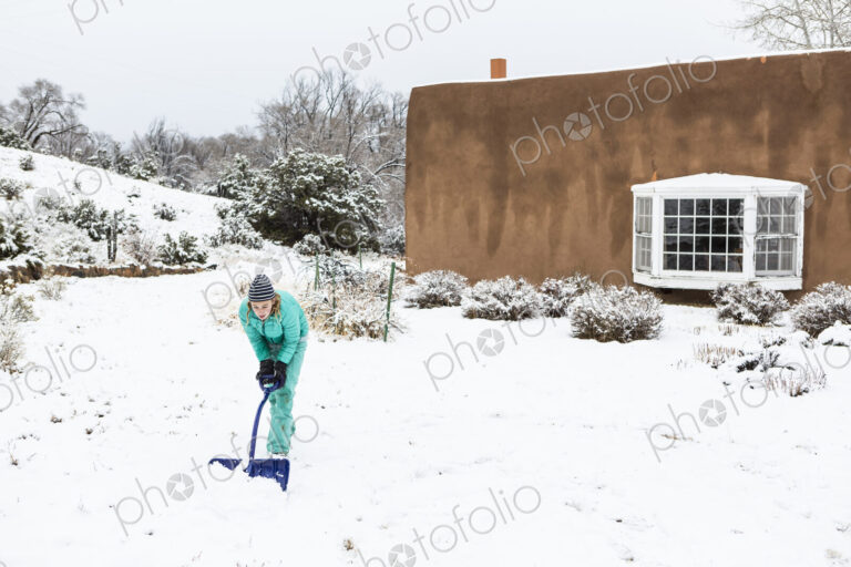 Thirteen year old teenage girl building a snowman