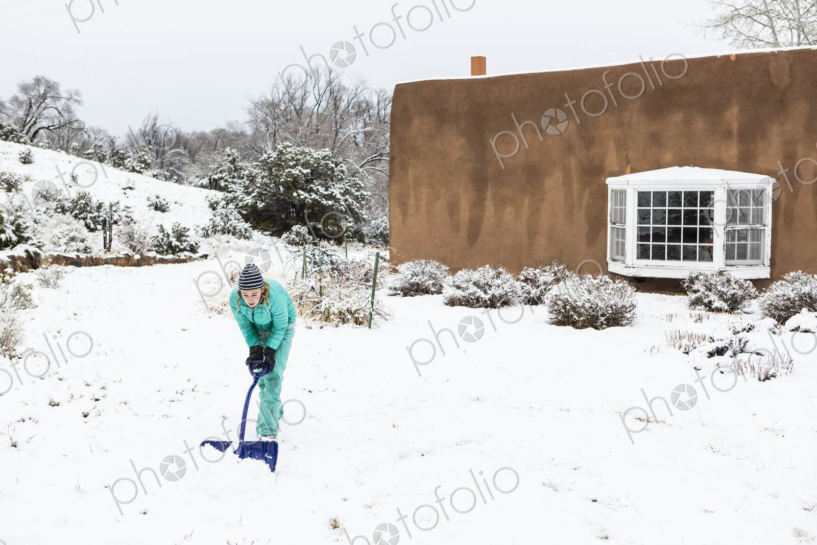 Thirteen year old teenage girl building a snowman