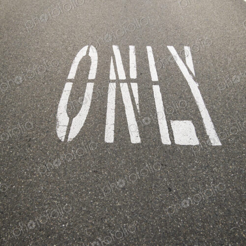 This way only road, Ahead Only with arrow symbols painted on the road surface. This way only road, Ahead Only with arrow symbols painted on the road surface.