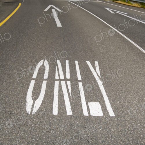 This way only road, Ahead Only with arrow symbols painted on the road surface. This way only road, Ahead Only with arrow symbols painted on the road surface.