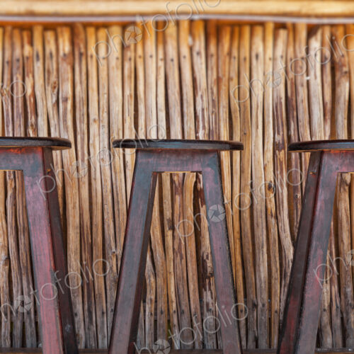 Three bar stools and bar on a beach Three bar stools and bar on a beach