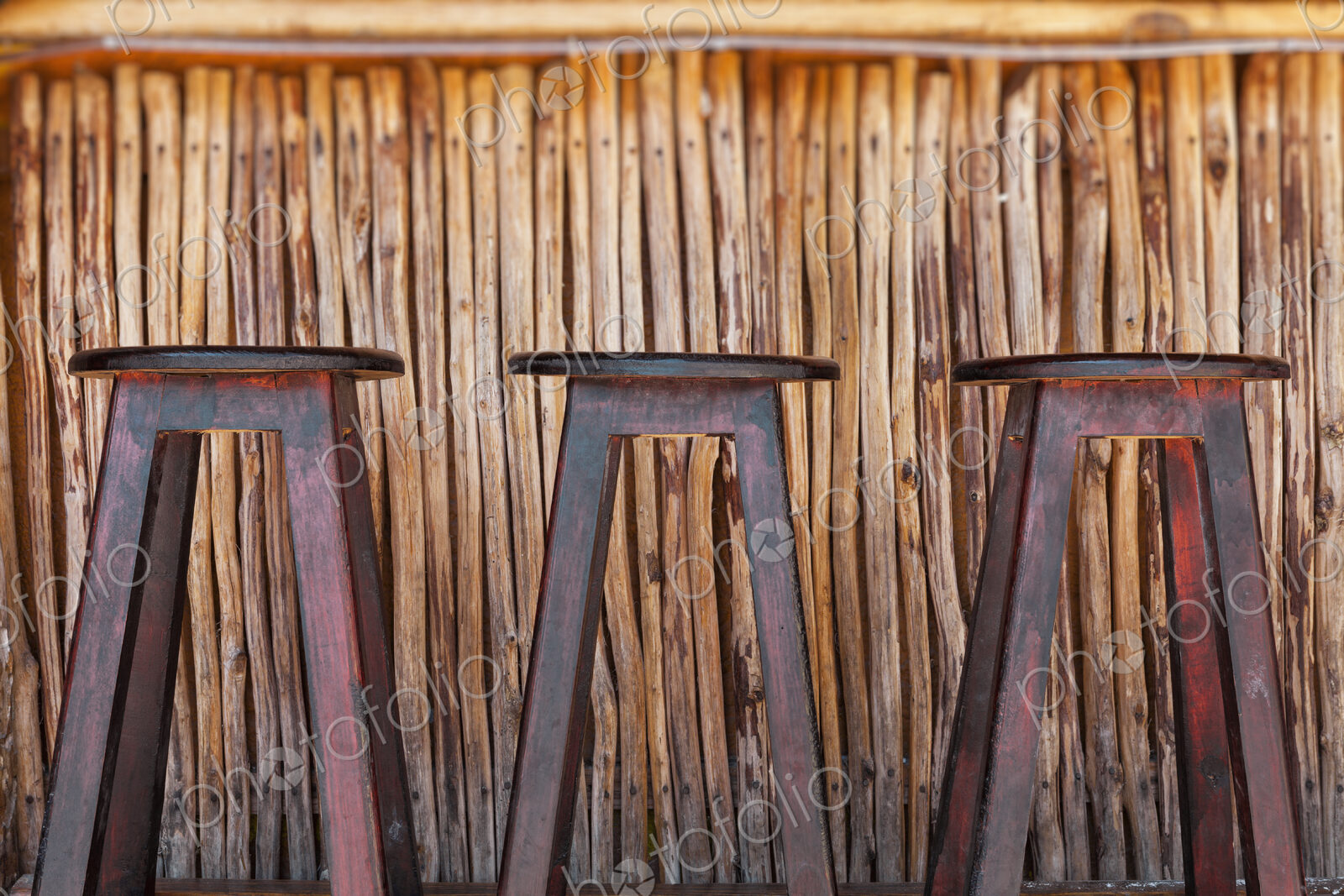 Three bar stools and bar on a beach