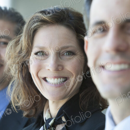 Three business people, head and shoulders, looking at camera portrait.