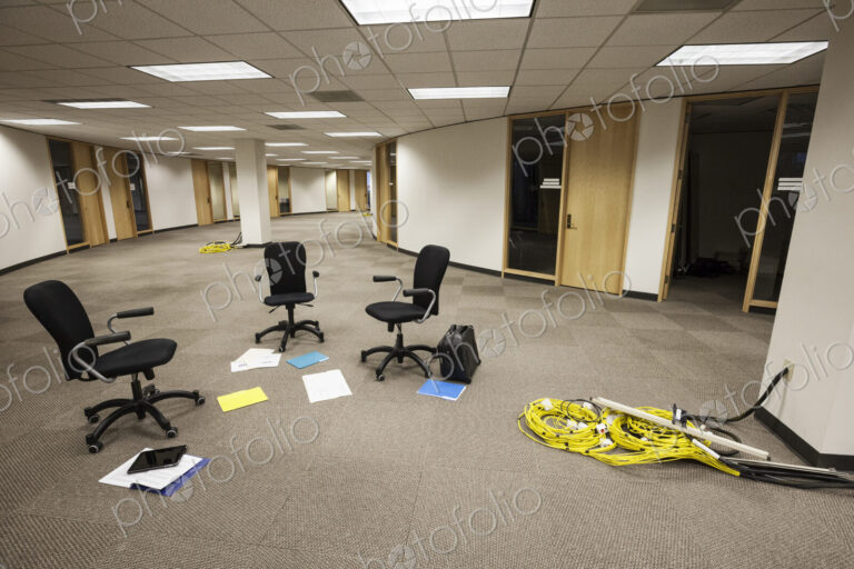 Three chairs sitting alone in an open area in an unoccupied office space.