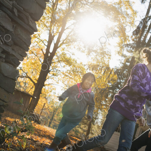 Three children in the autumn sunshine. Playing outdoors throwing the fallen leaves in… Three children in the autumn sunshine. Playing outdoors throwing the fallen leaves in…