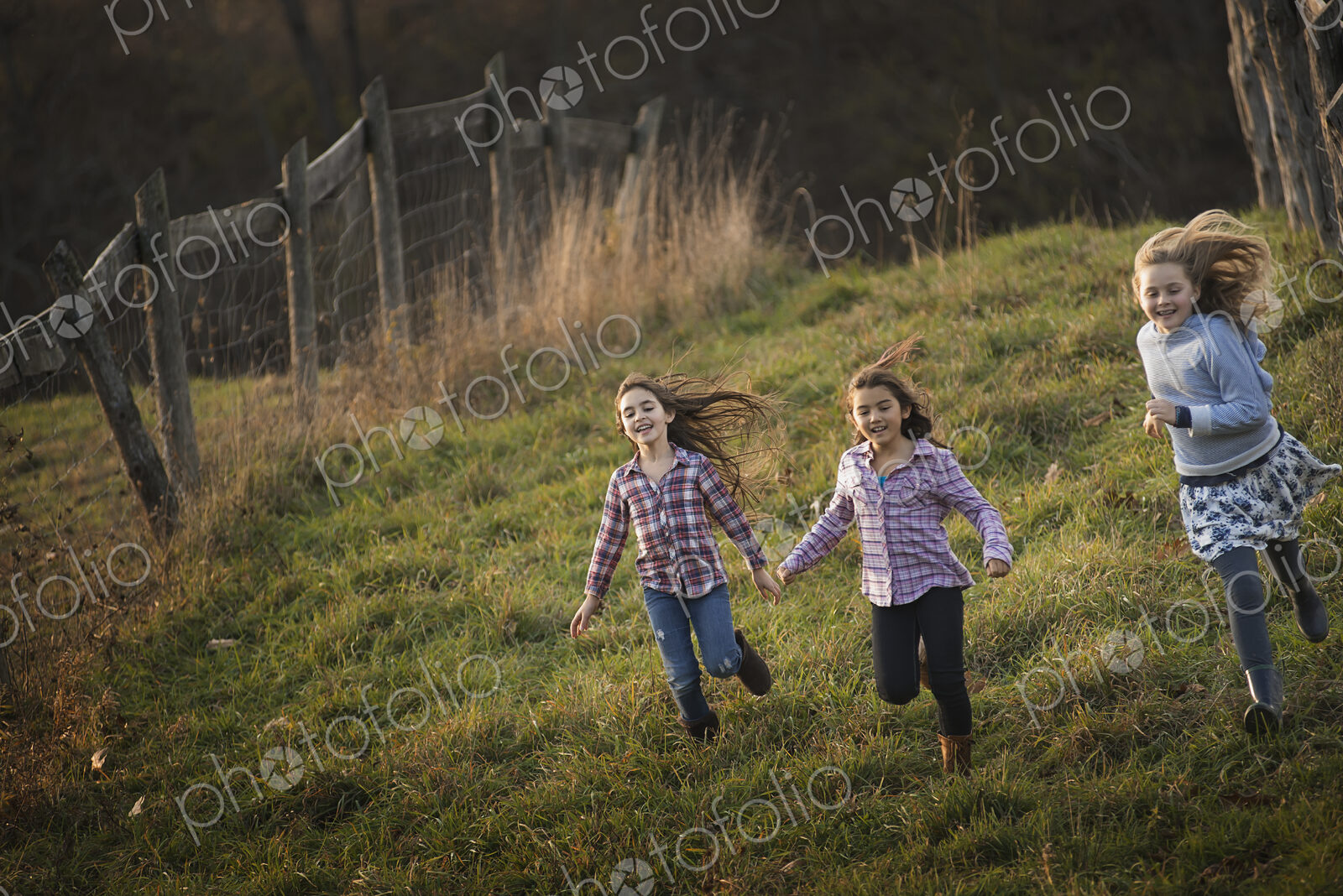 Three children running down a hill on an organic farm.