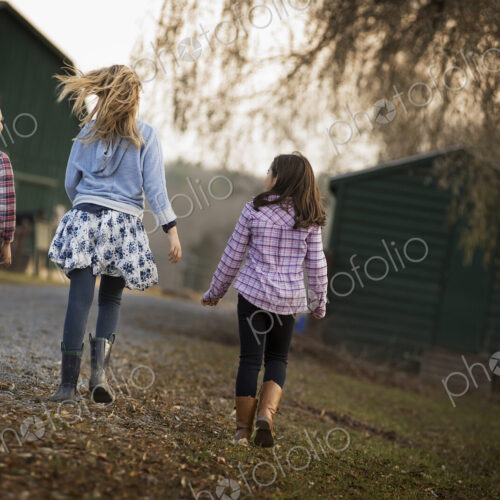 Three children walking along a path on an organic farm. Three children walking along a path on an organic farm.