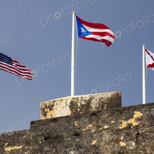 Three flags - the United States flag, the Puerto Rican flag, and the historic Cross of… Three flags - the United States flag, the Puerto Rican flag, and the historic Cross of…