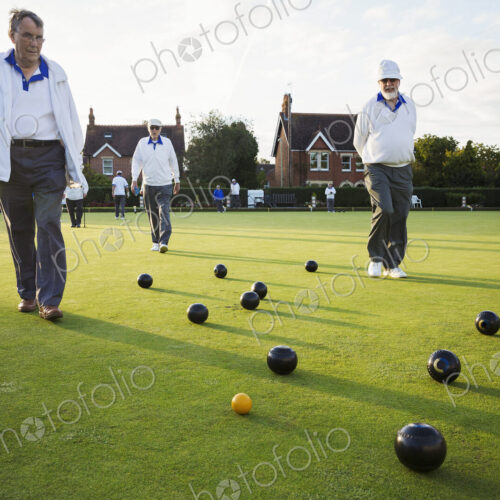 Three lawn bowls players, men walking across the green, the playing surface, at an end… Three lawn bowls players, men walking across the green, the playing surface, at an end…