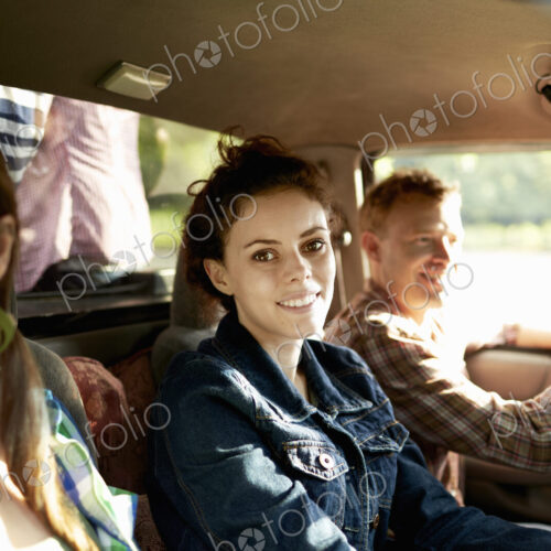 Three passengers in the cab of a pickup truck. One young man driving. Two young women…