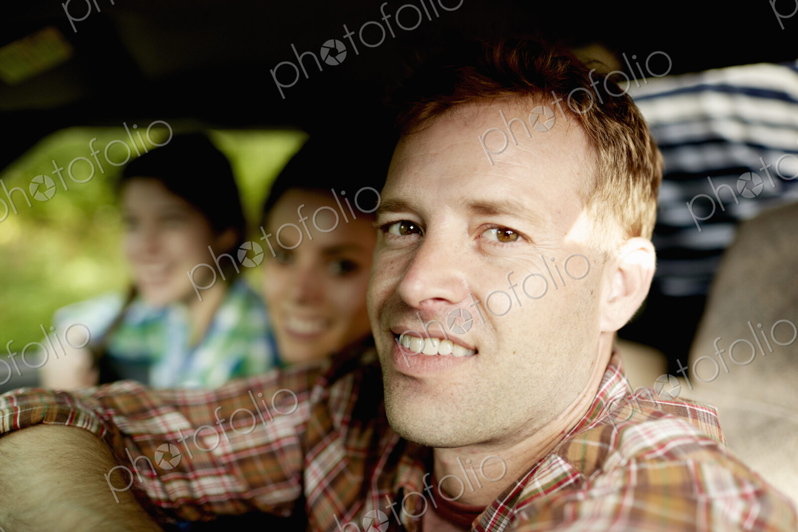 Three passengers in the cab of a pickup truck. One young man driving. Two young women…