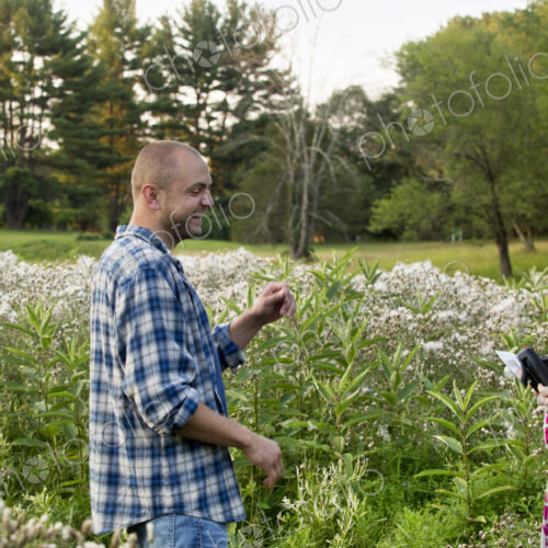 Three people, a man and two women in a wildflower meadow.