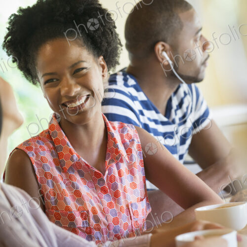 Three people in a room, one wearing headphones and two in conversation. Three people in a room, one wearing headphones and two in conversation.