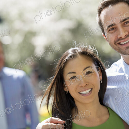 Three people in business dress. A couple side by side smiling at the camera. A man in… Three people in business dress. A couple side by side smiling at the camera. A man in…