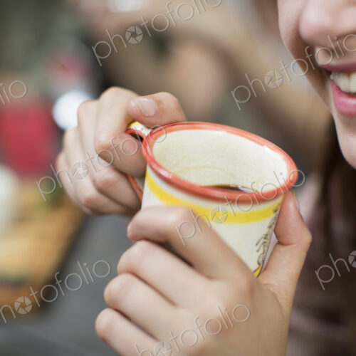 Three people seated around a table in a woodland clearing, one holding a mug with both… Three people seated around a table in a woodland clearing, one holding a mug with both…