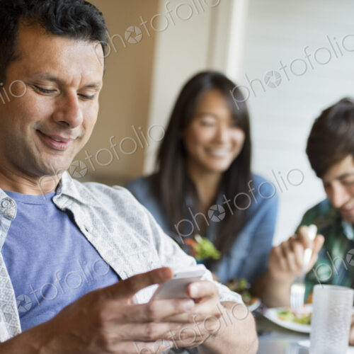 Three people seated at a cafe table.