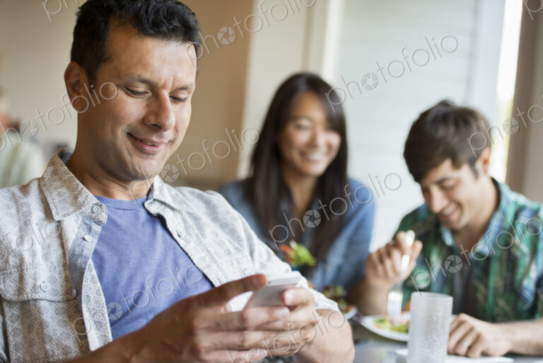 Three people seated at a cafe table.