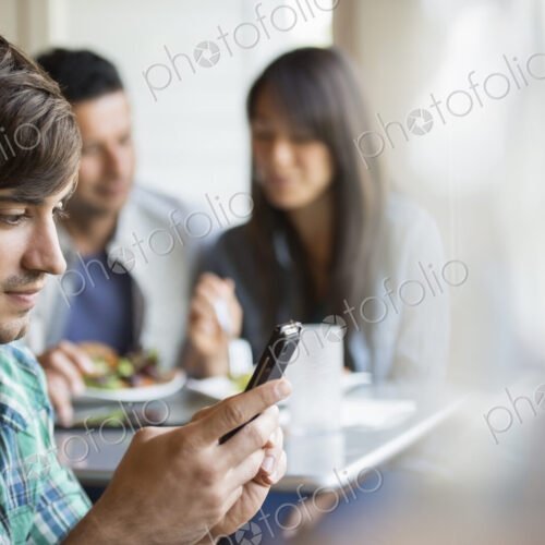 Three people seated at a cafe table. Three people seated at a cafe table.