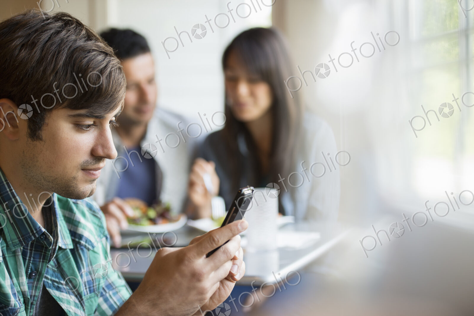 Three people seated at a cafe table.