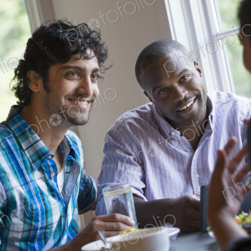 Three people seated at a table. Three people seated at a table.