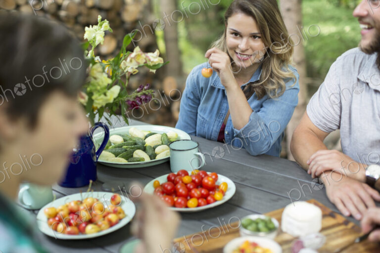 Three people seated outdoors at a meal