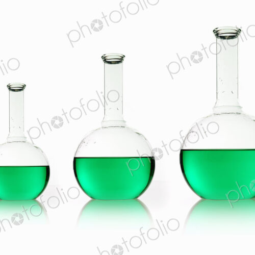 Three rounded shaped scientific chemical flasks holding green liquid, arranged in size… Three rounded shaped scientific chemical flasks holding green liquid, arranged in size…