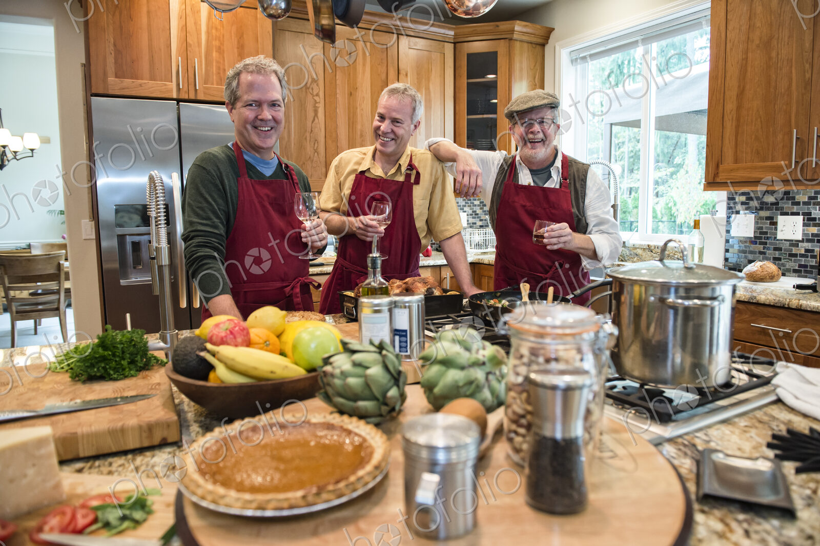Three senior men friends cooking a meal in the kitchen.