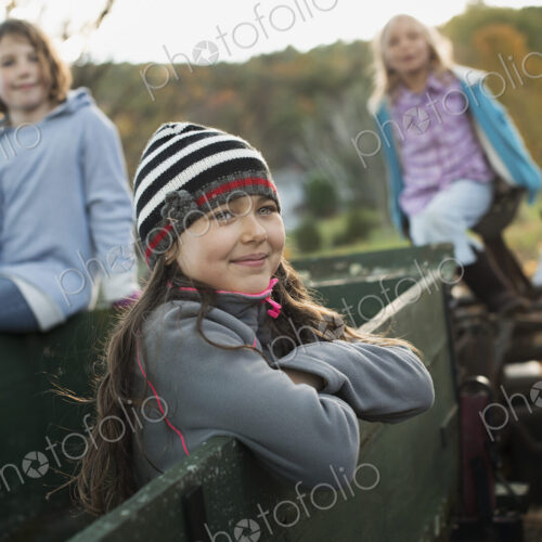 Three young girls out and about on the farm. On an old trailer. Three young girls out and about on the farm. On an old trailer.