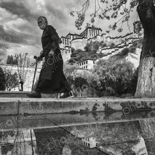 Tibetan Woman Walking Past the Potala Palace Lhasa, Autonomous Region of Tibet