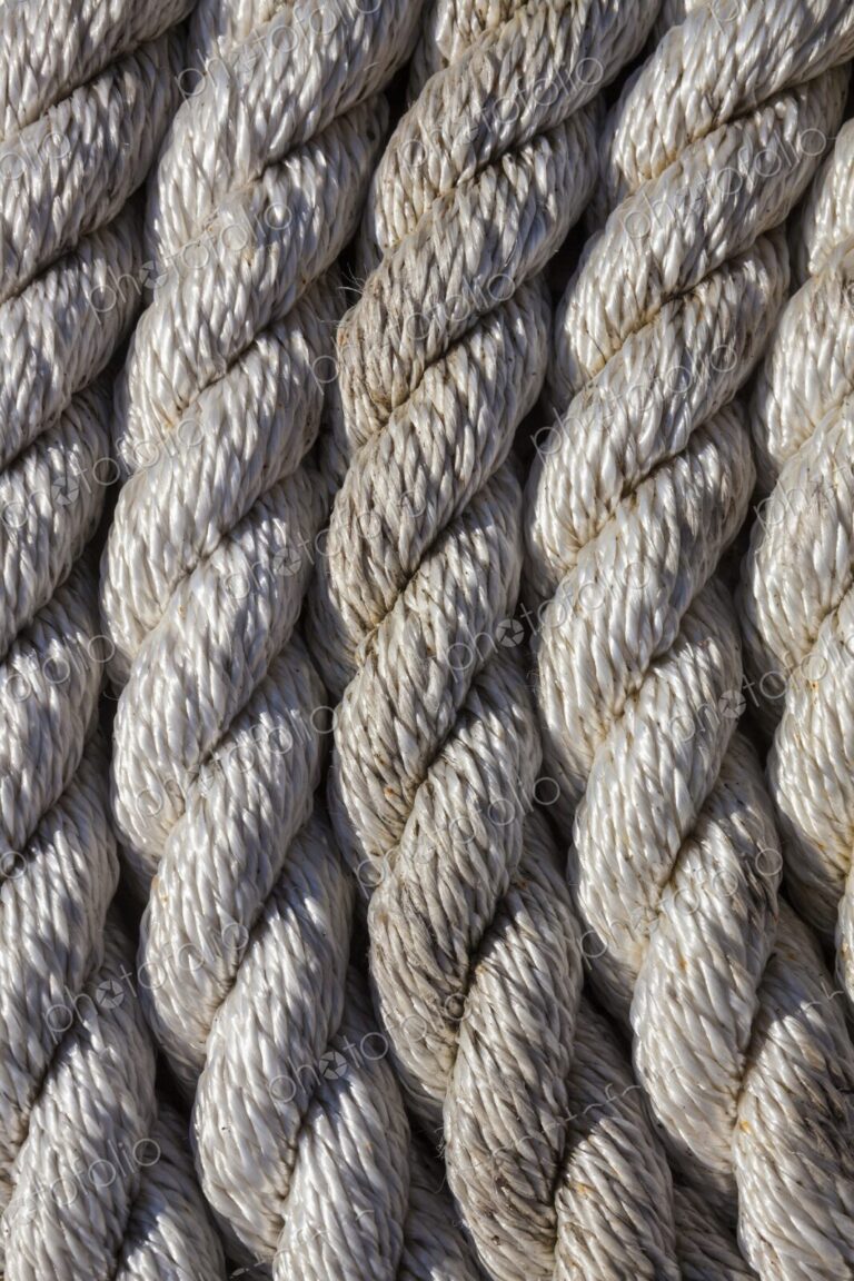 Tightly coiled rope on a dock at Charleston Marina, Oregon, showing detailed texture…