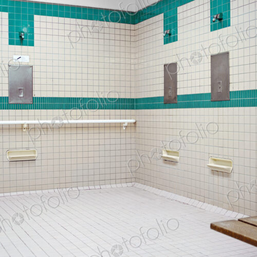 Tiled public shower room for use before entering the swimming pool area at a… Tiled public shower room for use before entering the swimming pool area at a…