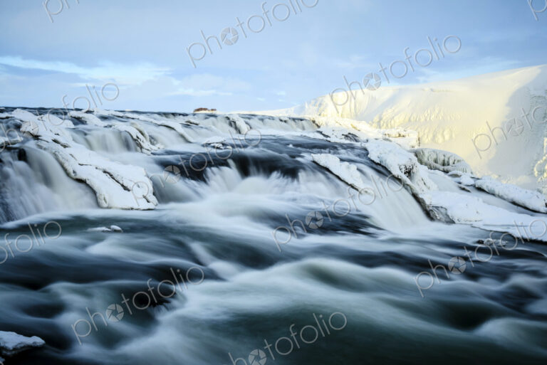 Time lapse view of river flowing over icy rock formations