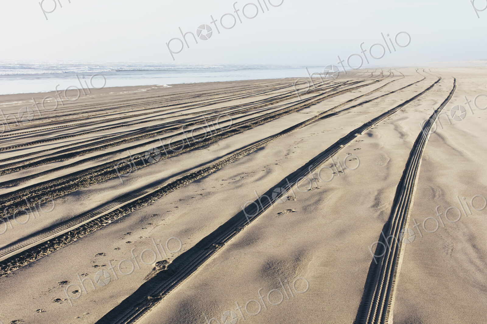 Tire tracks on the soft surface of sand on a beach.