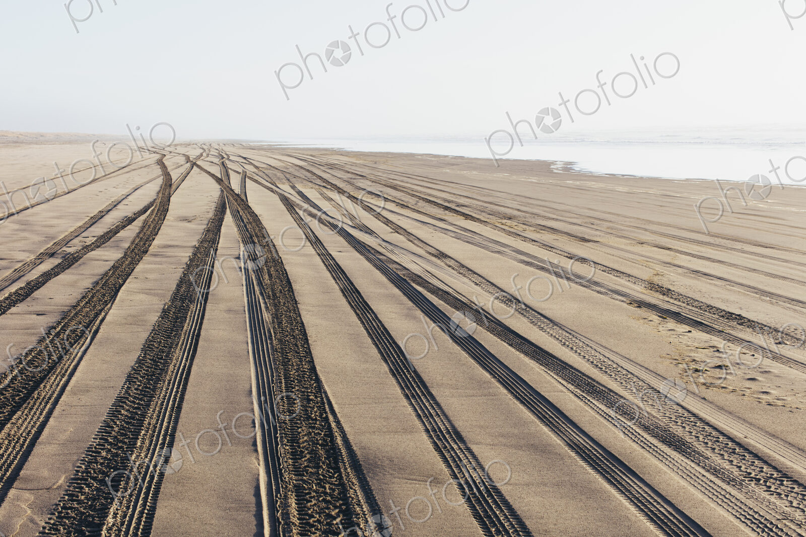 Tire tracks on the soft surface of sand on a beach.