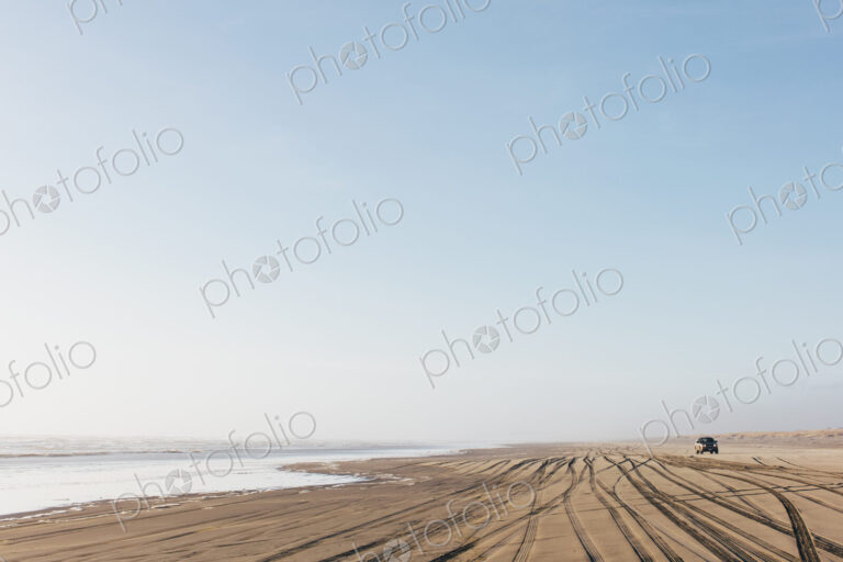 Tire tracks on the soft surface of sand on a beach.