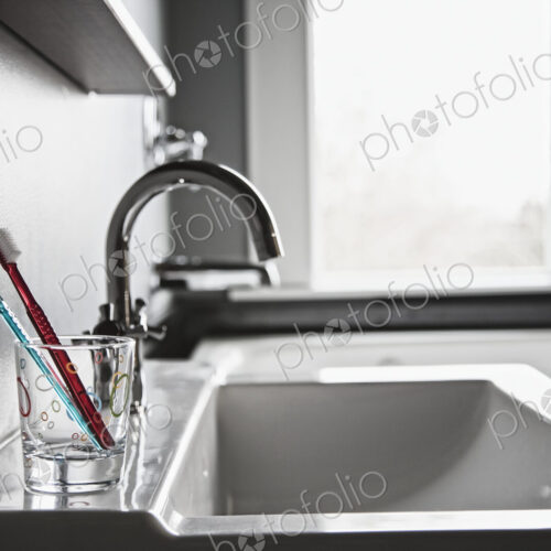 Toothbrushes in drinking glass in domestic bathroom. Toothbrushes in drinking glass in domestic bathroom.