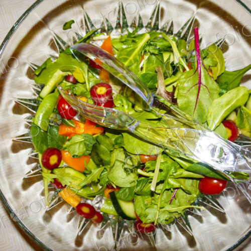 Top view of salad in a clear glass bowl fresh salad leaves and tomatoes. Top view of salad in a clear glass bowl fresh salad leaves and tomatoes.