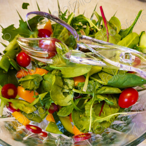 Top view of salad in a clear glass bowl fresh salad leaves and tomatoes. Top view of salad in a clear glass bowl fresh salad leaves and tomatoes.