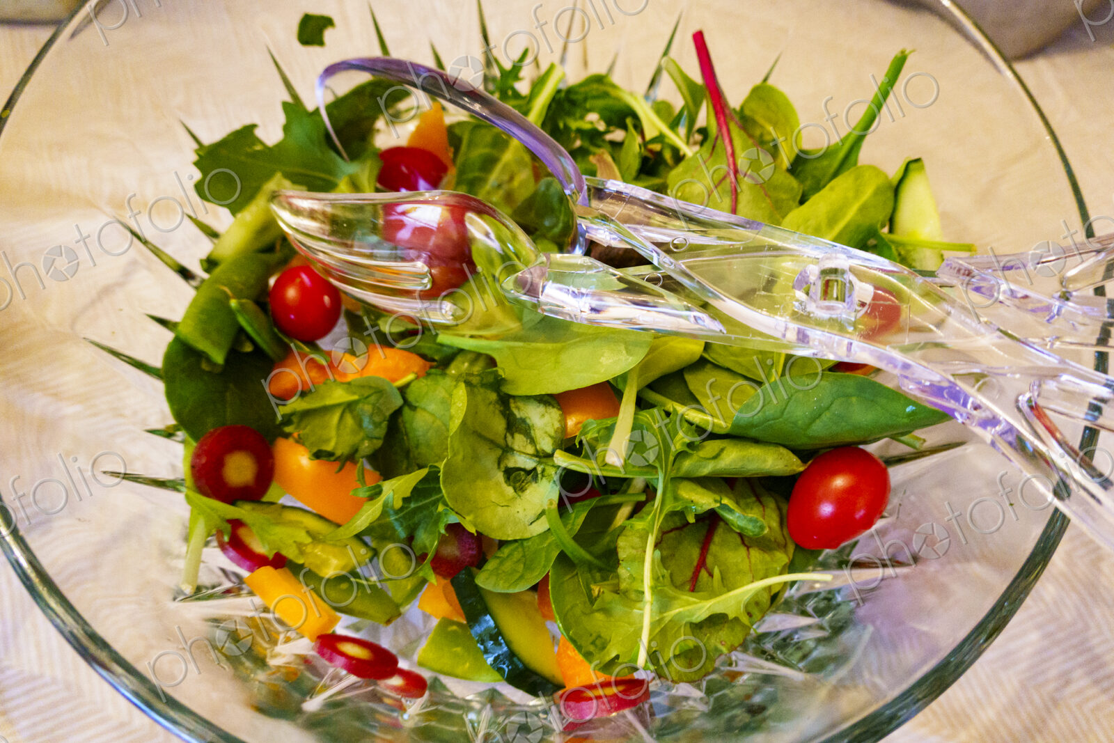 Top view of salad in a clear glass bowl fresh salad leaves and tomatoes.