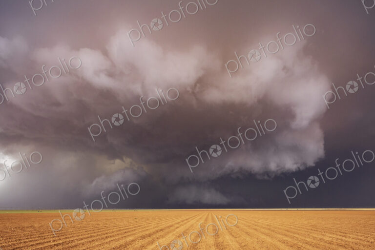 Tornado-Producing Supercell, clouds gathering above a cornfield, dark shapes on the…