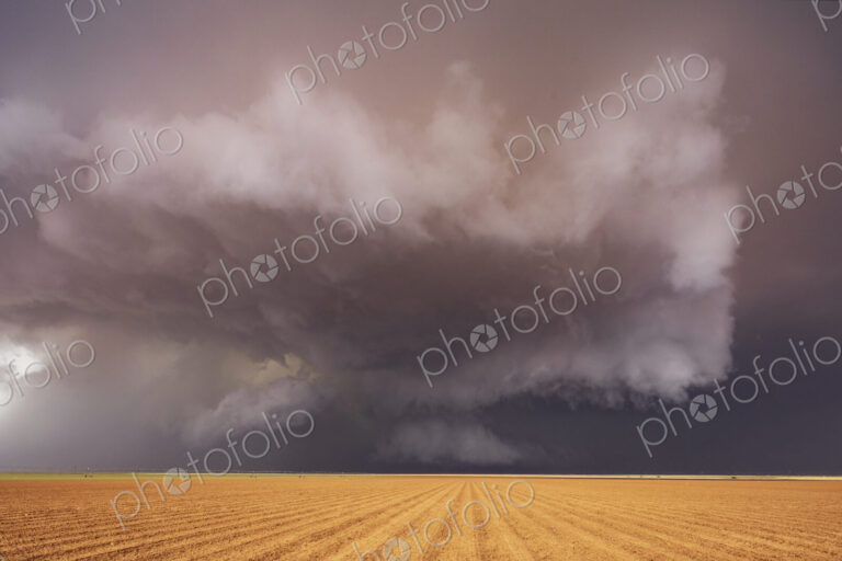 Tornado-Producing Supercell, clouds gathering above a cornfield, dark shapes on the…