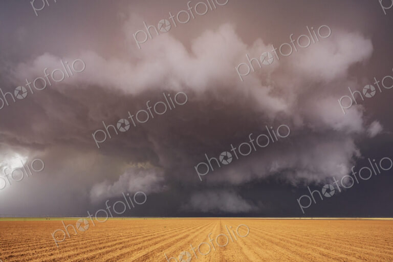 Tornado-Producing Supercell, clouds gathering above a cornfield, dark shapes on the…