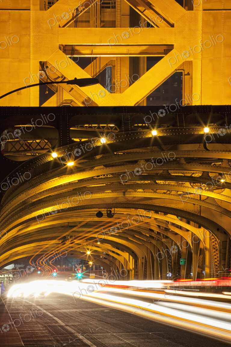 Tower Bridge at night, the roadway across the bridge with curved arches and the…