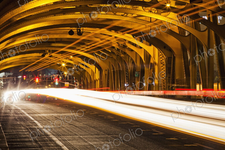 Tower Bridge at night, the roadway across the bridge with curved arches and the…