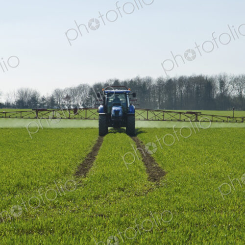 Tractor and crop-sprayer in field.
