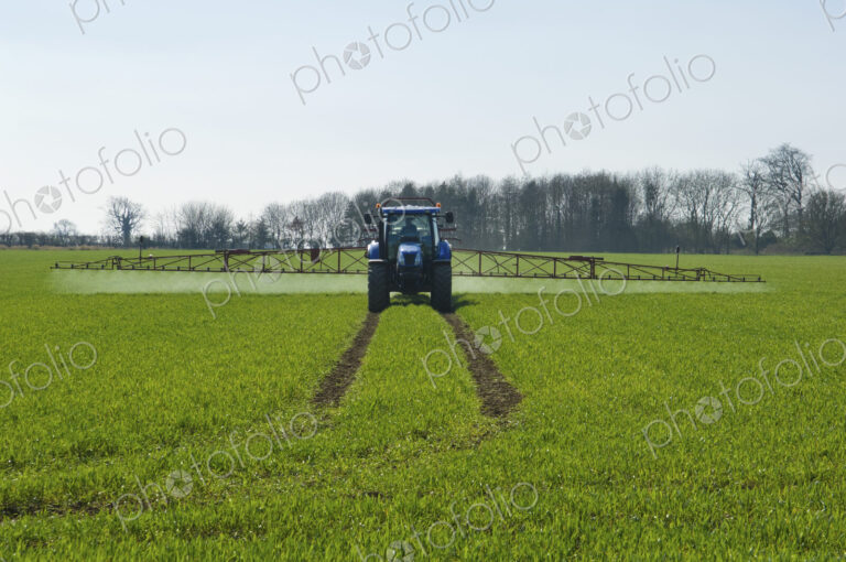 Tractor and crop-sprayer in field.